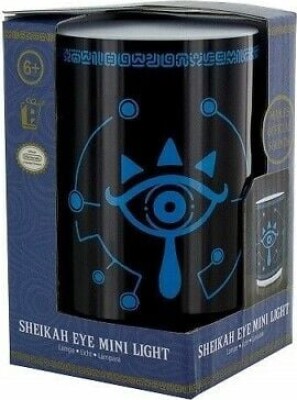 Sort cylinderlampe med det blå Sheikah-øje fra Zelda, stående foran sin æske